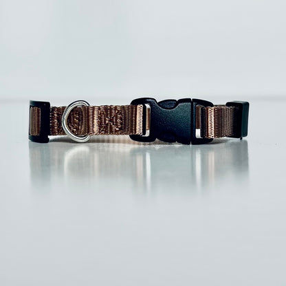 Bronze brown dog collar with a black buckle on a light grey background
