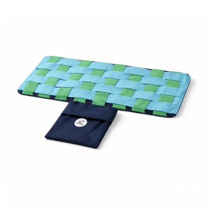Woven blue and green mat with a pouch on a white background